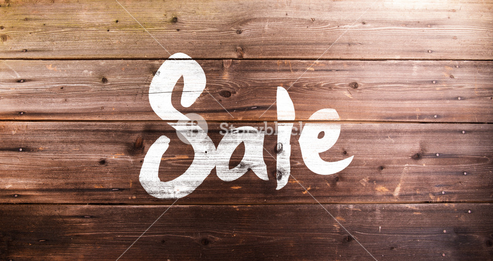 Chalk sale sign. Studio shot on wooden background.