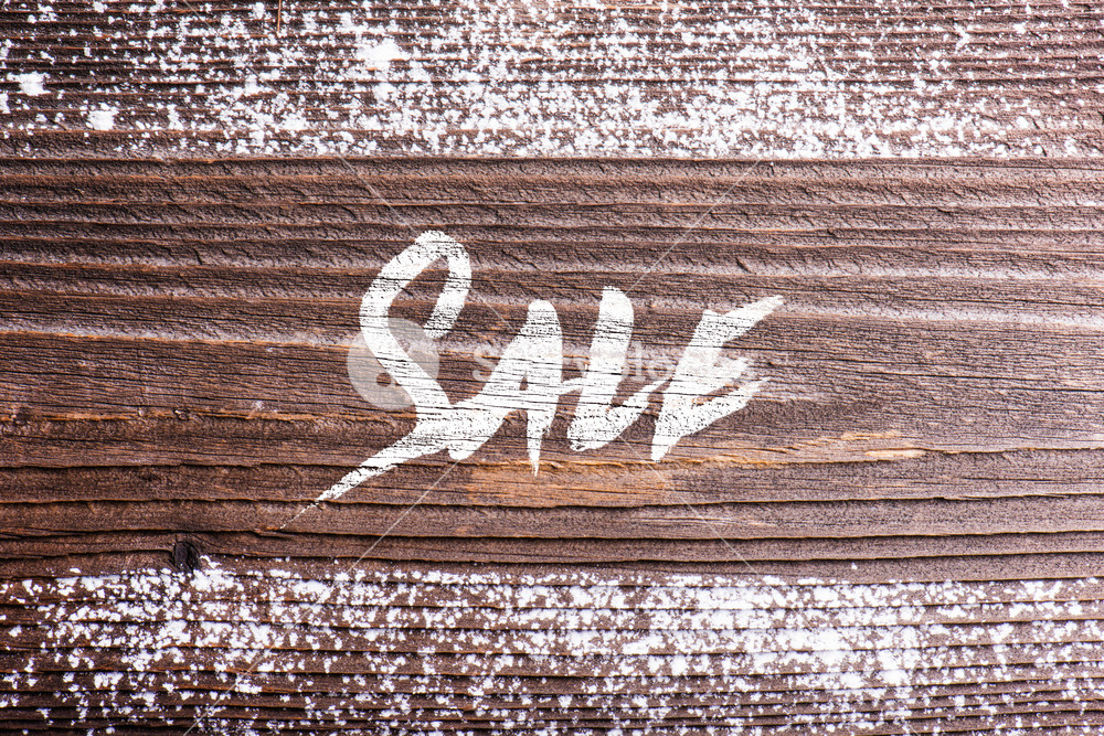 Chalk sale sign. Studio shot on wooden background.