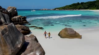 Anse Cocos beach la Digue Seychelles, a couple of men and women on a tropical beach during a luxury vacation in Seychelles. white tropical beach near Petite Anse La Digue